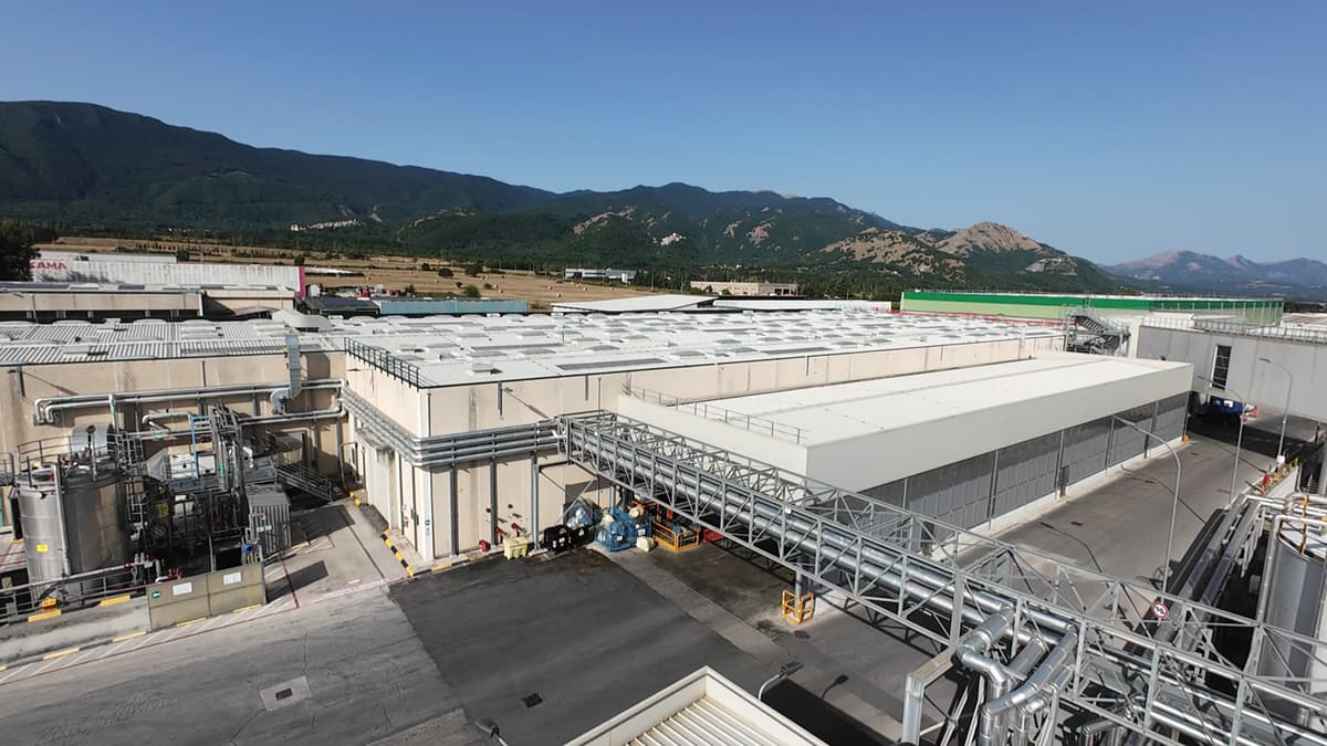 Veduta aerea da drone di uno stabilimento industriale con le montagne sullo sfondo