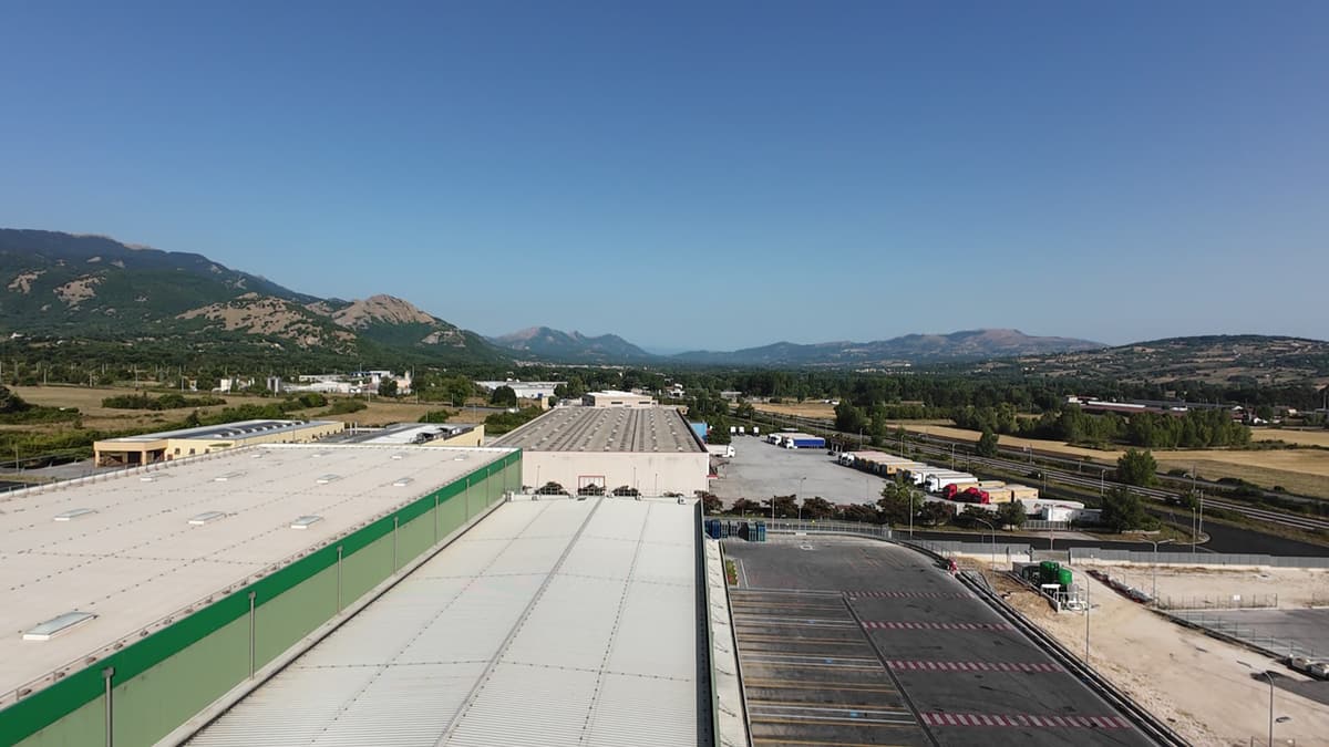 Ripresa da drone di una copertura industriale con le montagne sullo sfondo