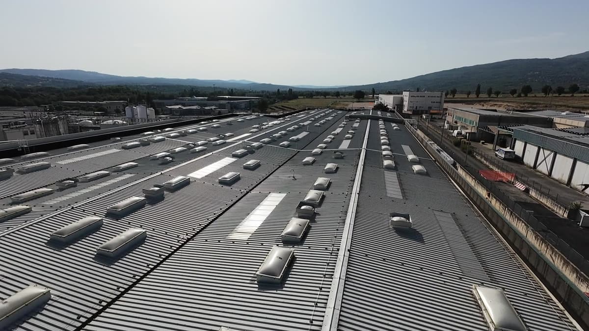 Drone in volo di ispezione sopra la copertura di uno stabilimento industriale